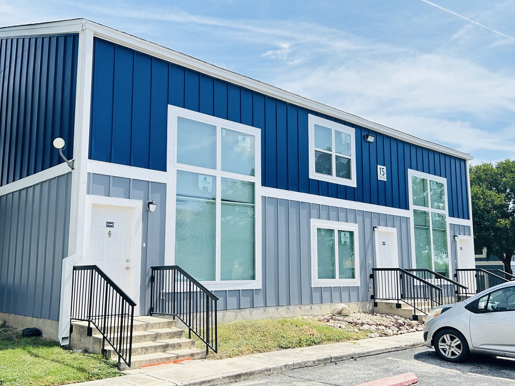A blue and white building with a car parked in front.