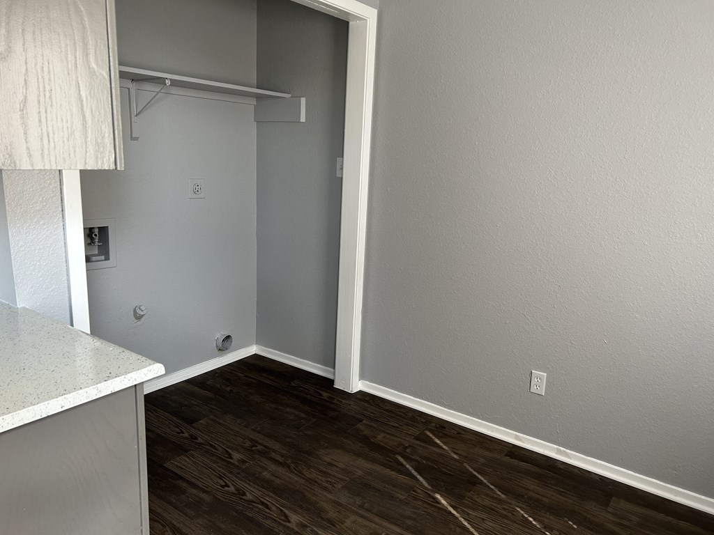 an empty room with wood flooring and a closet