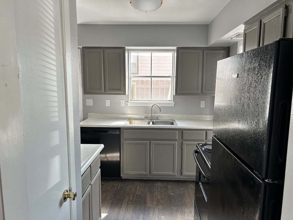 an empty kitchen with stainless steel appliances and a window