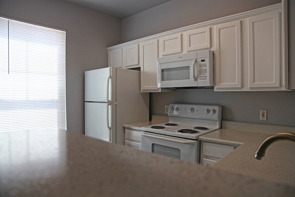 a kitchen with white appliances and white cabinets