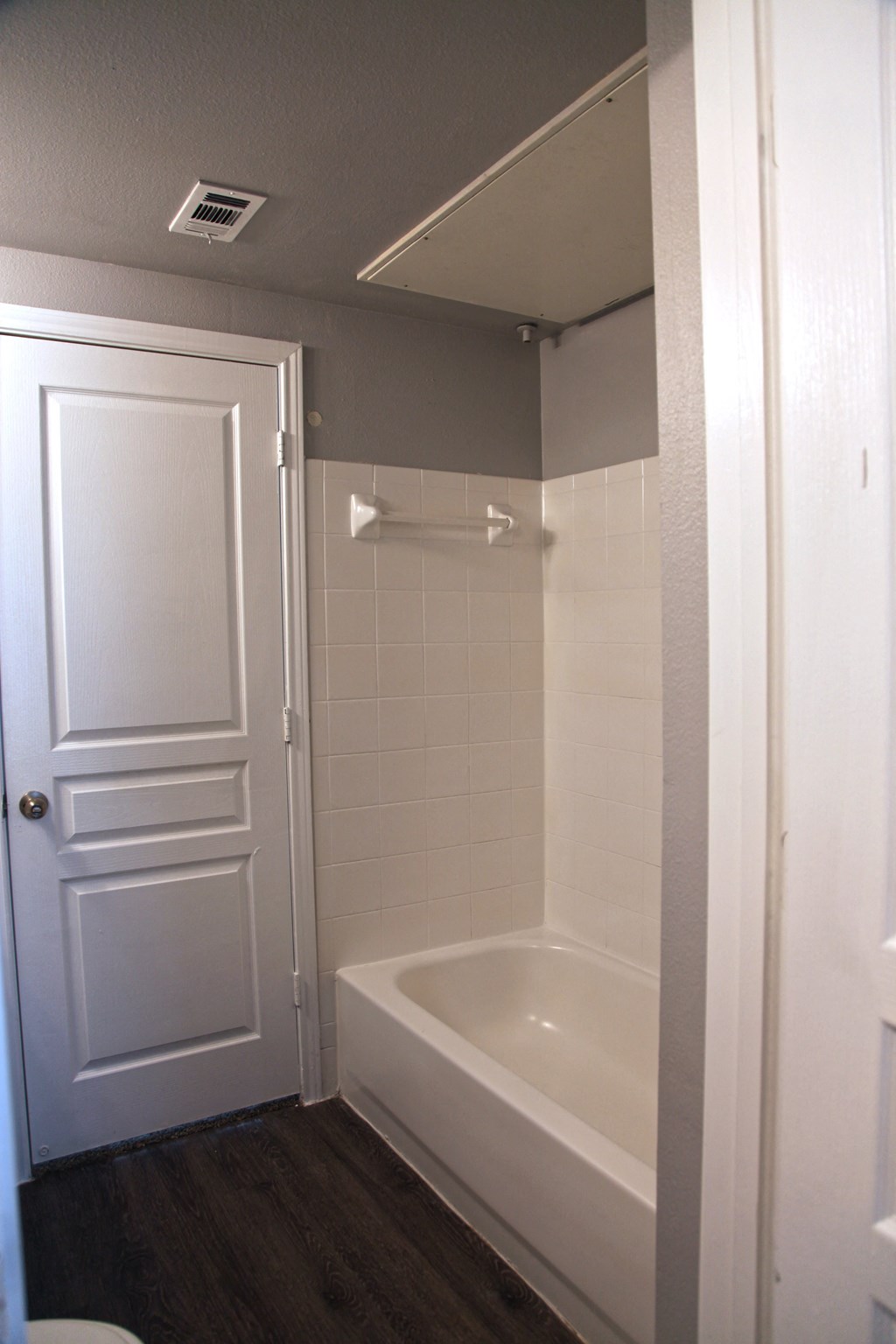 a small bathroom with a tub and a door