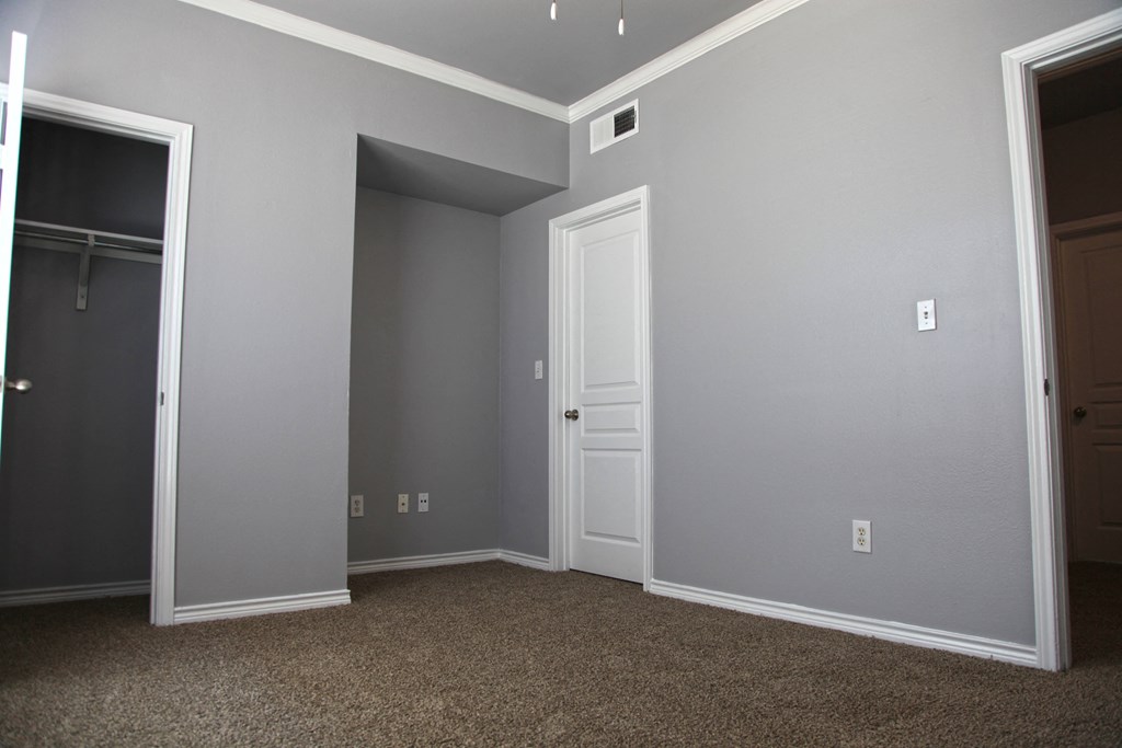 a bedroom with grey walls and a closet and a door