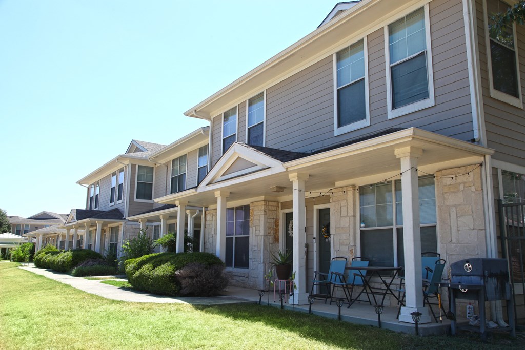 a row of houses with tables and chairs in front of them