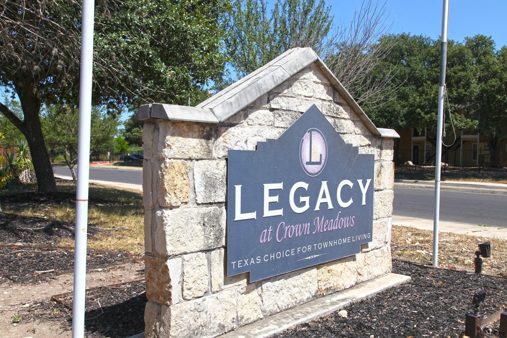 a sign for legacy at crown heights in front of a street