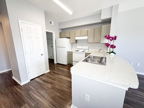 A kitchen with a white counter top and a sink.