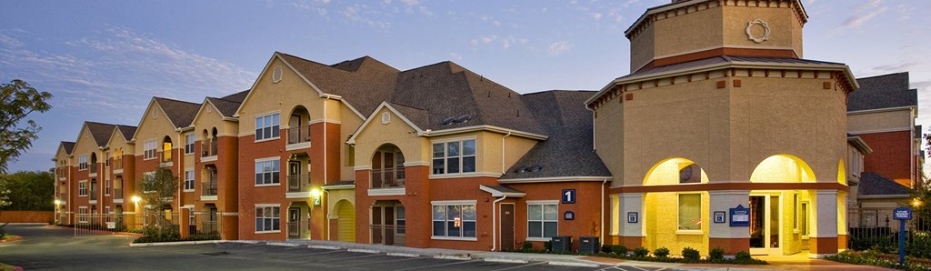 a row of townhouses on a street at dusk