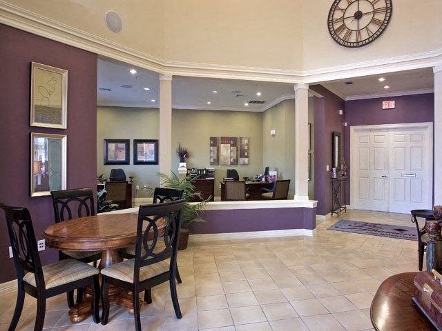a lobby with a table and chairs and a clock