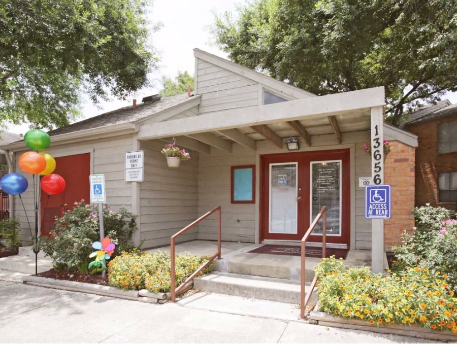Exterior of leasing office with beige paint and red door framing