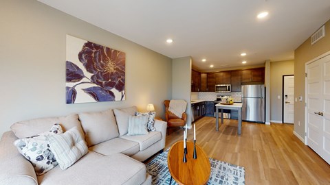 A living room with a couch, a guitar, and a painting on the wall.