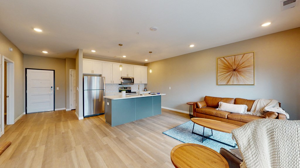 a living room with a couch and a kitchen