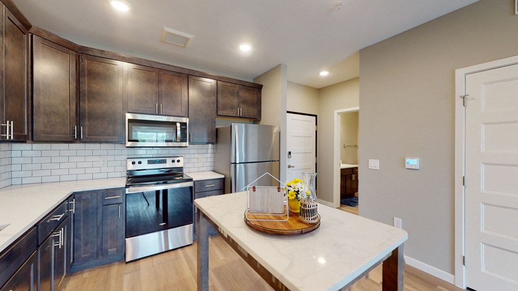 a modern kitchen with stainless steel appliances and wooden cabinets