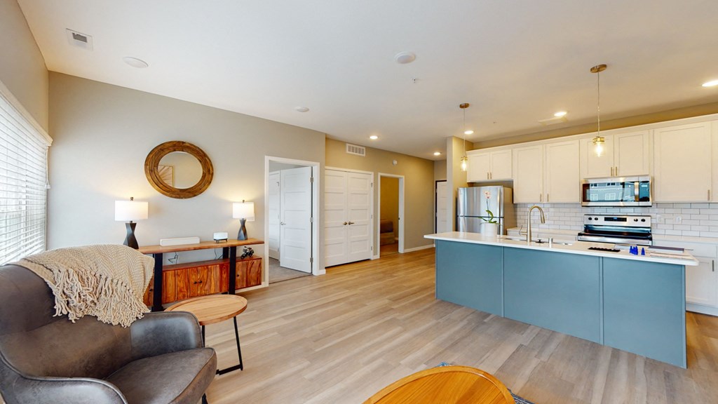 a living room and kitchen with a blue counter top