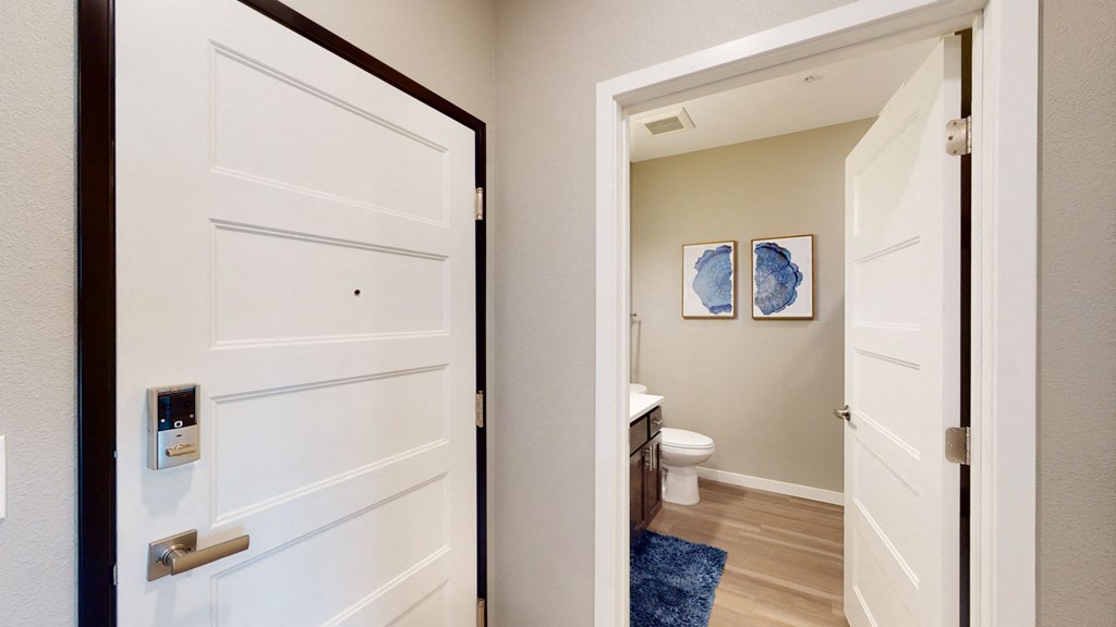 an open door leading into a bathroom with a toilet and a sink