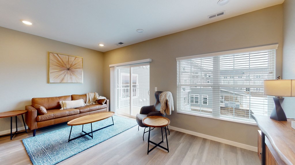 a living room with a couch and a chair and a window