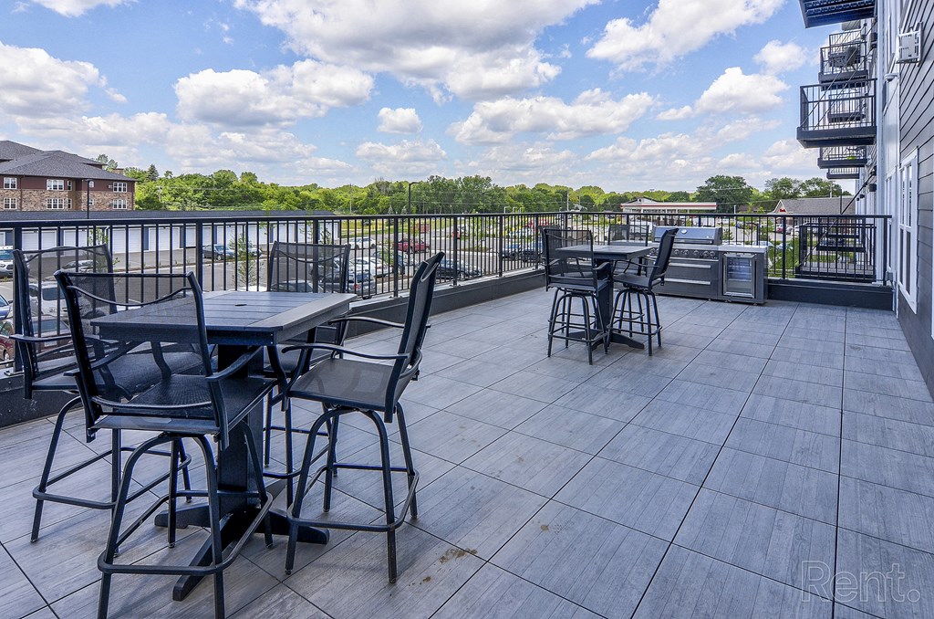 a patio with tables and chairs on top of a roof