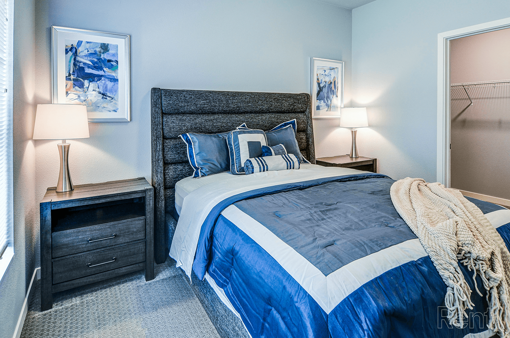 a bedroom with a bed and blue and white comforter