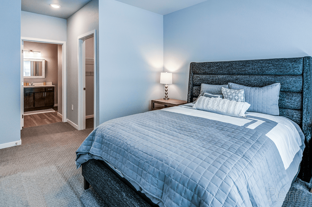 a bedroom with a large bed and a bathroom