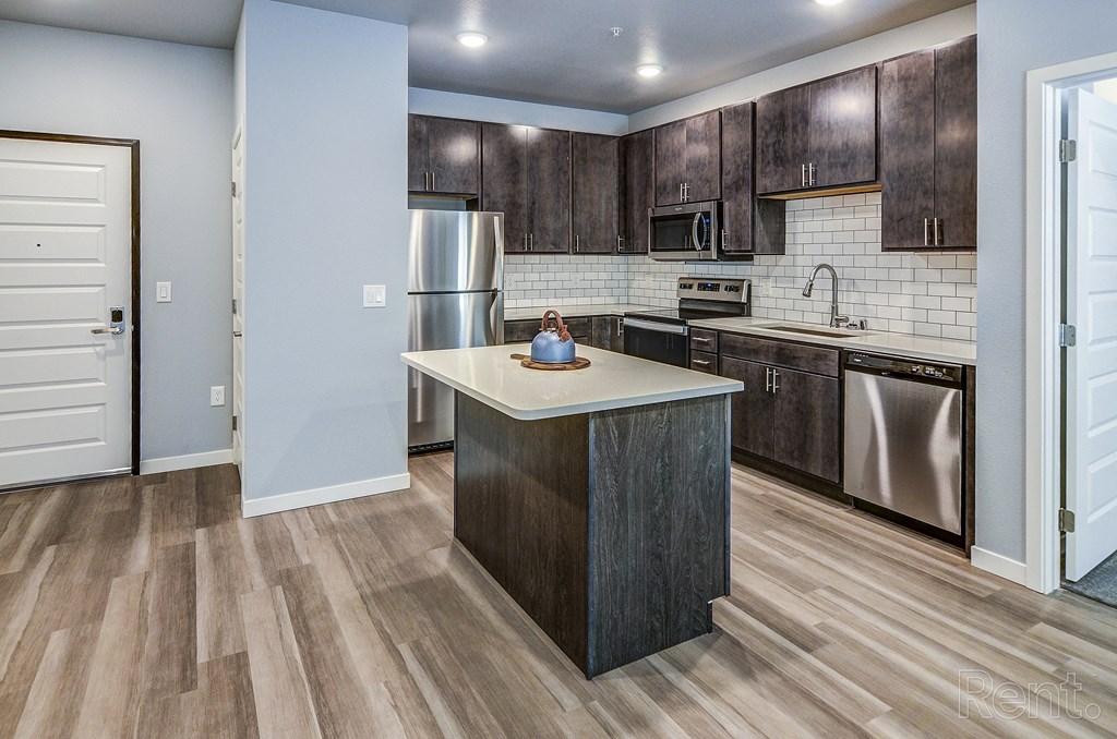 a kitchen with wooden cabinets and stainless steel appliances