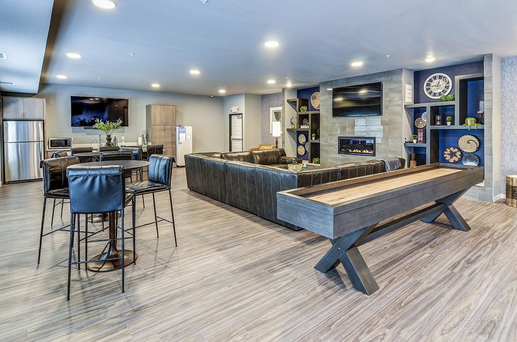 a game room with a shuffleboard table and a bar