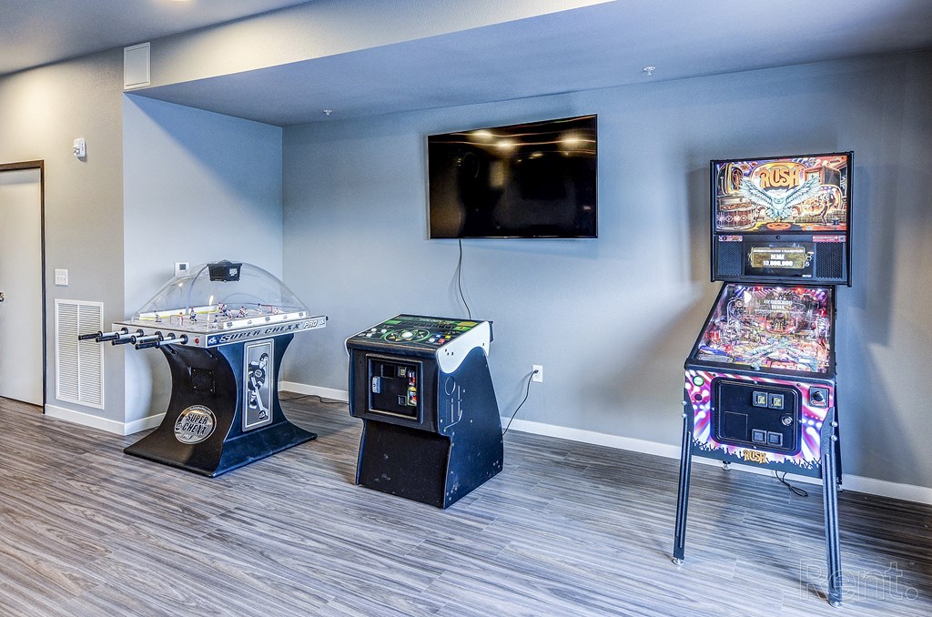 a room with two arcade games and a tv on the wall