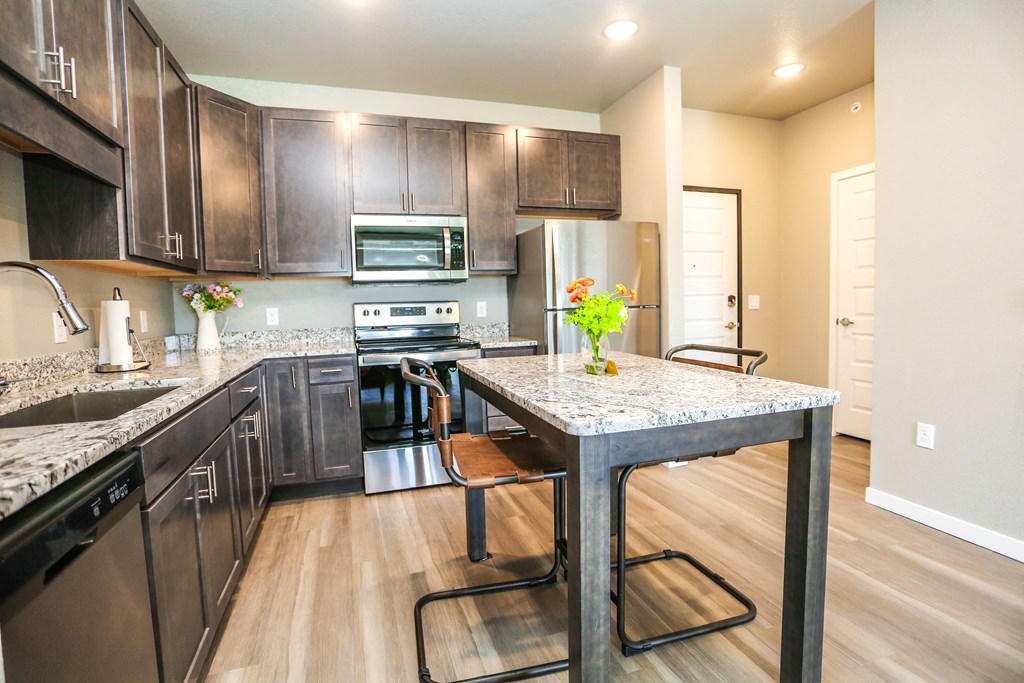 a large kitchen with stainless steel appliances and a granite counter top