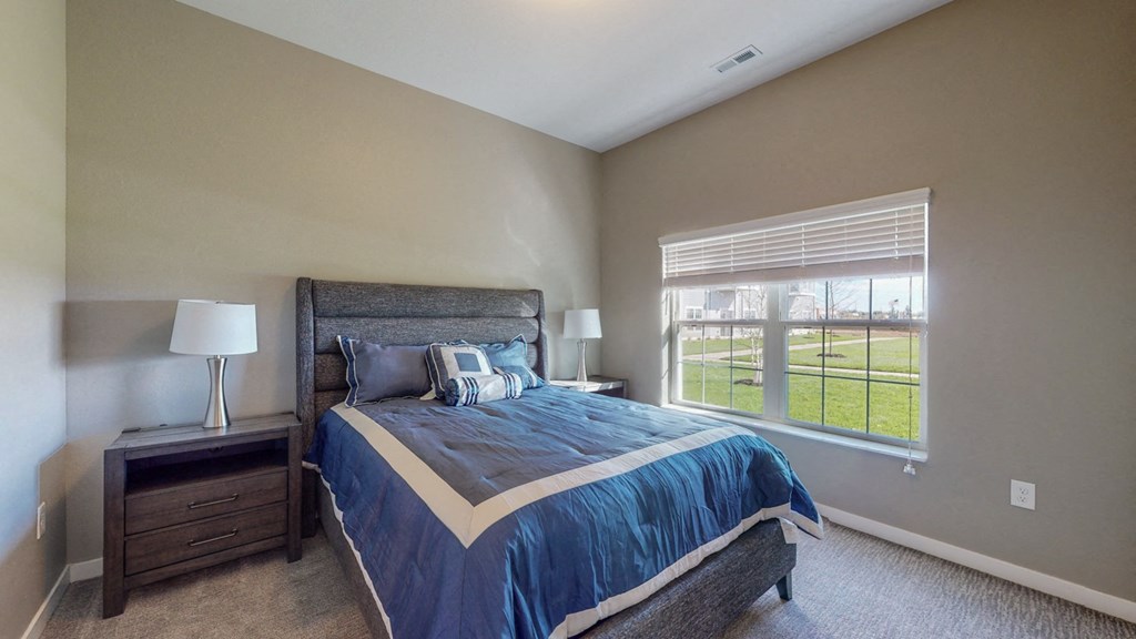 a bedroom with a bed and a large window