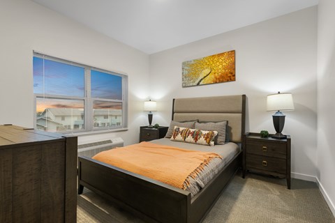 A bedroom with a large bed and a painting on the wall.