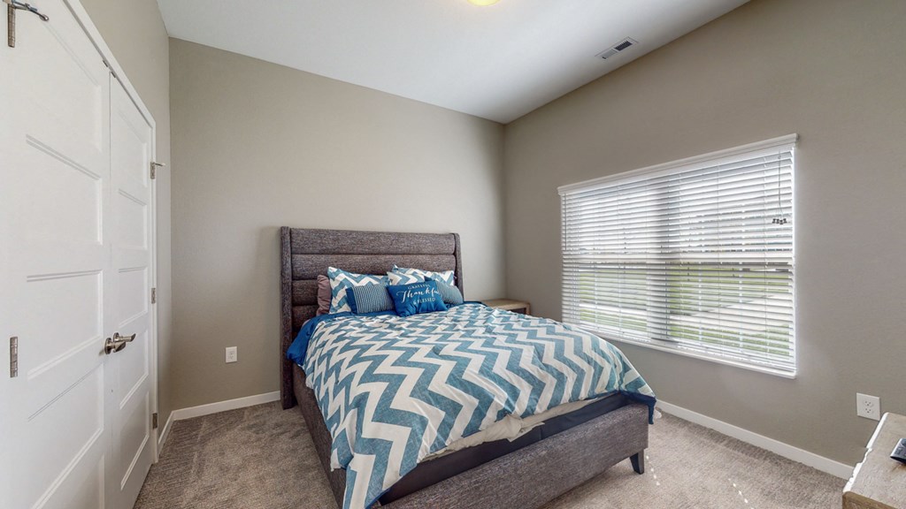 a bedroom with a bed and a large window