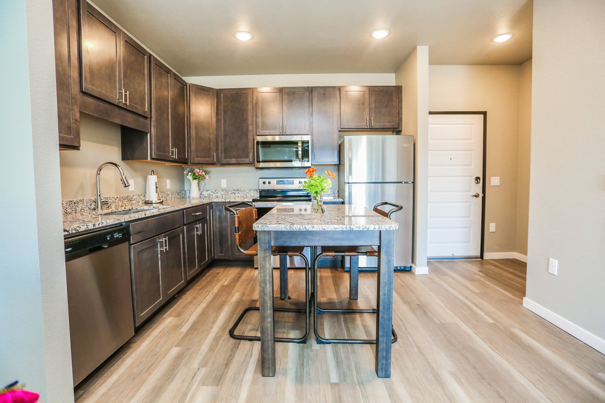 A kitchen with a table and chairs in the middle.