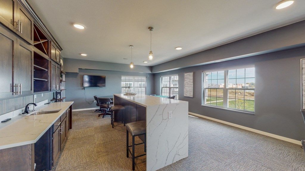 a kitchen with a marble counter top and a bar with chairs