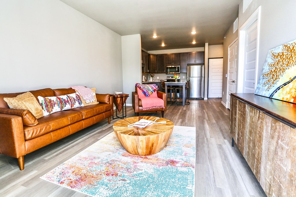 a living room with a couch and a table in front of a kitchen
