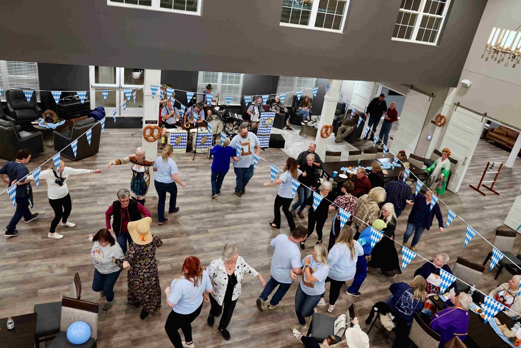 a large group of people dancing in an open room