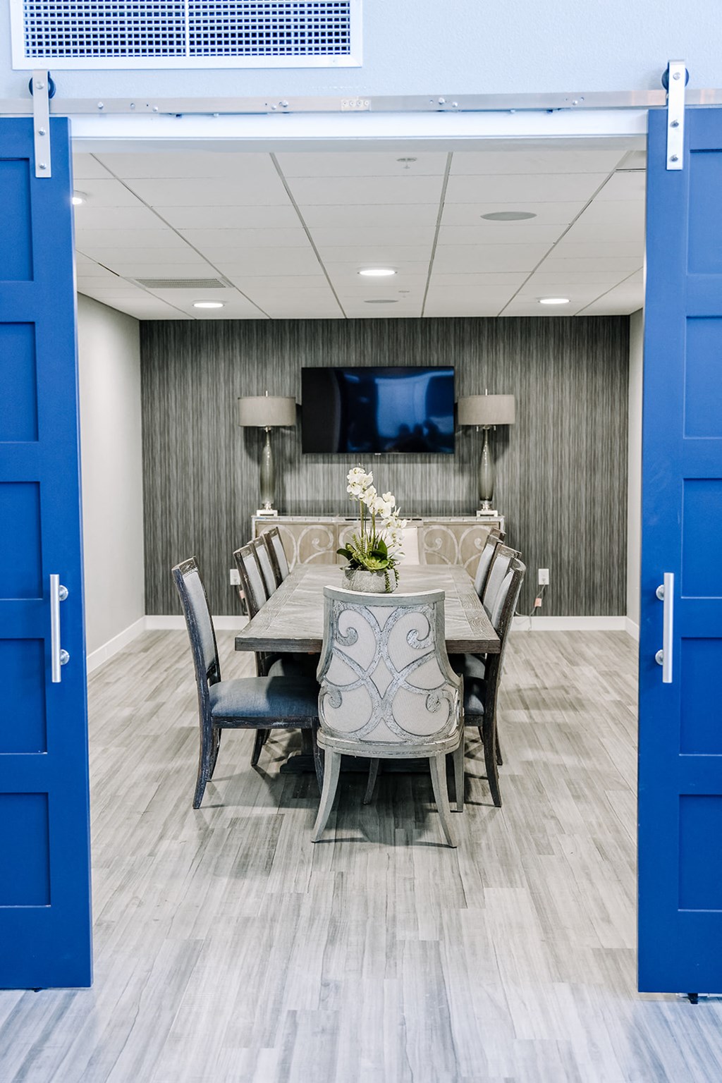 a conference room with blue doors and a table and chairs