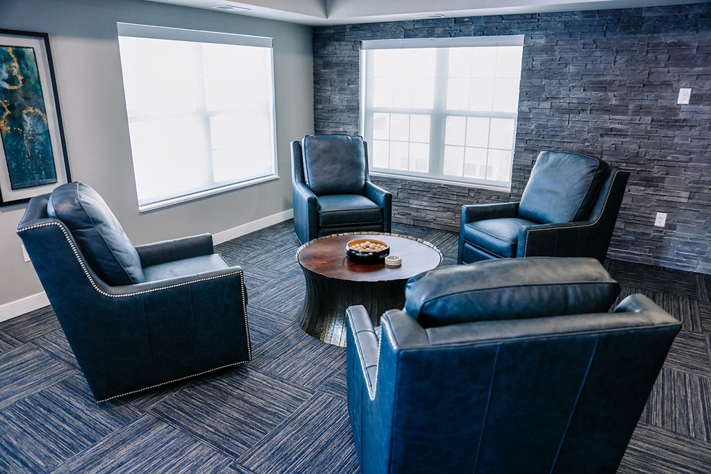 a lounge area with blue chairs and a coffee table