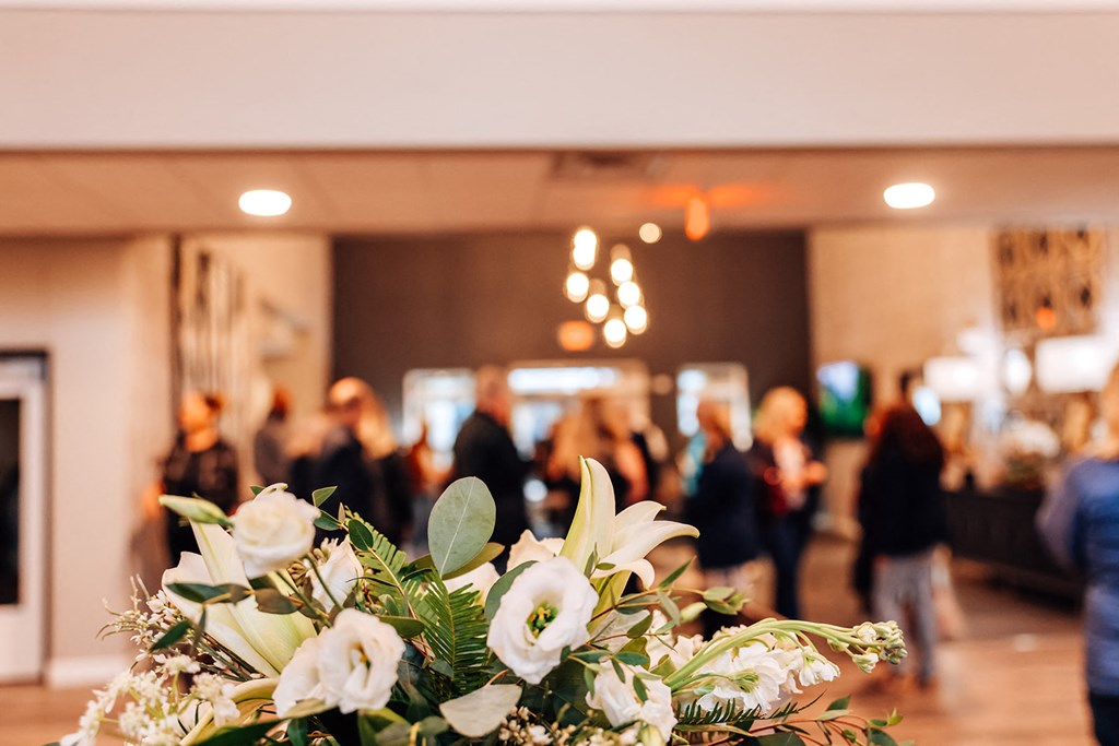 a vase of flowers with people in the background