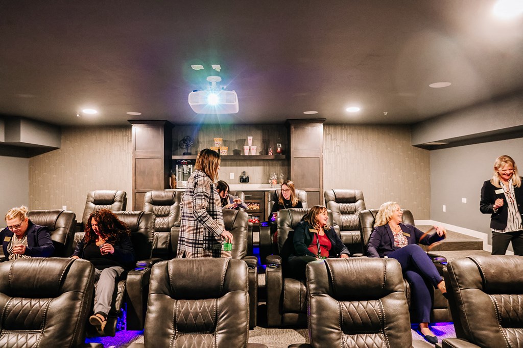 a group of people in a room with chairs and a projector