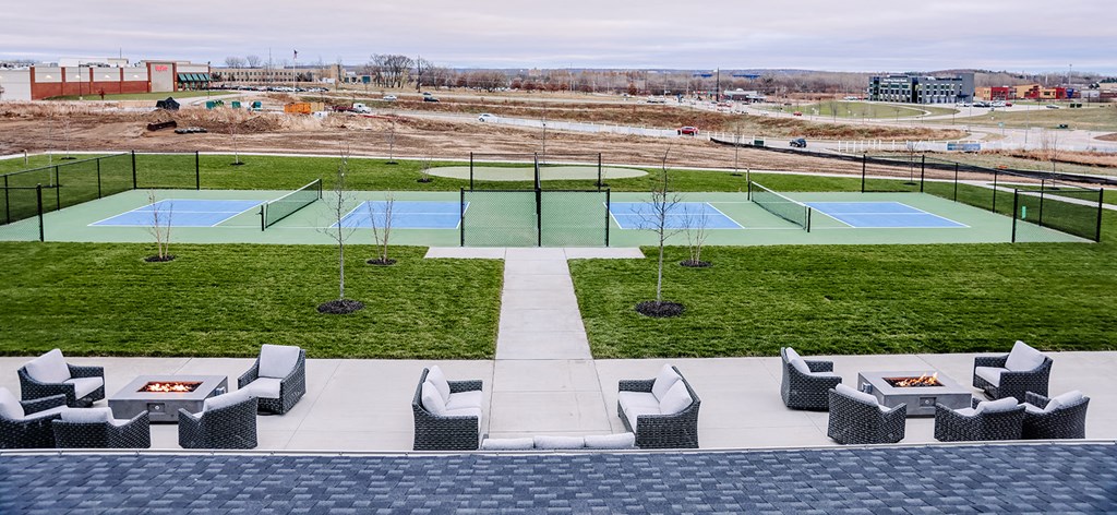 an aerial view of a tennis court with tables and chairs