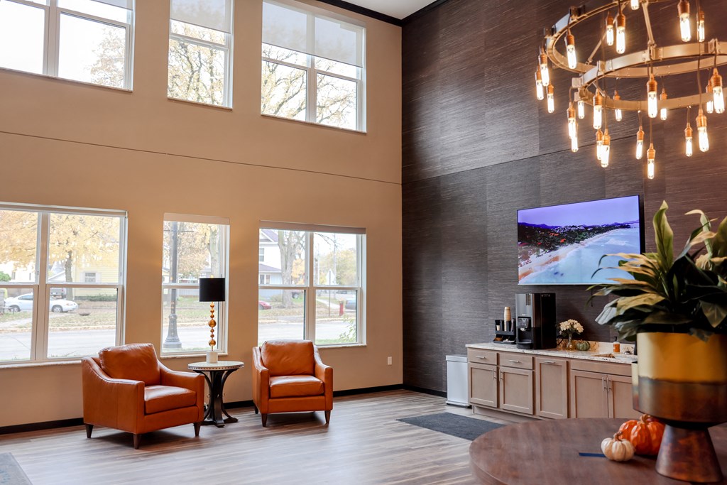a living room with orange chairs and a large chandelier