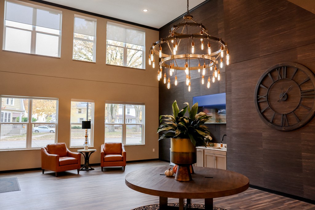 a living room with a large clock on the wall and a table