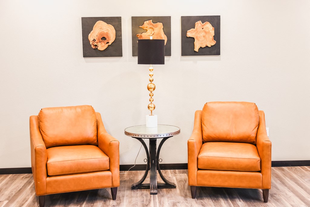 a living room with two orange chairs and a table