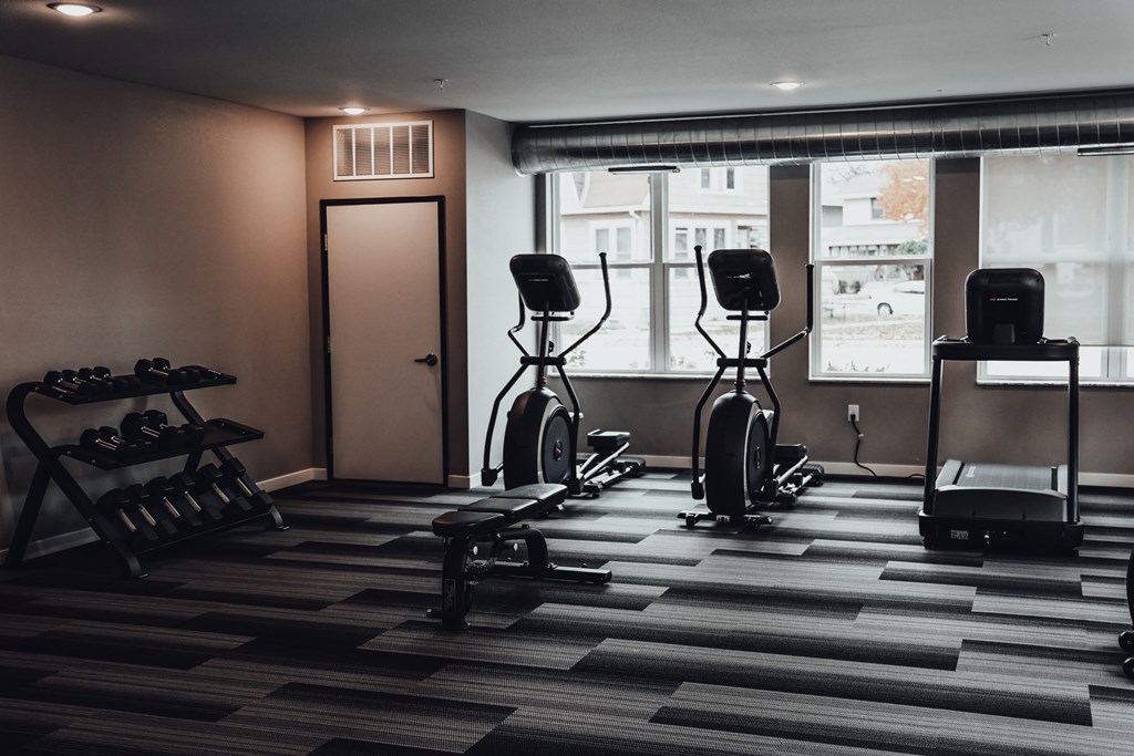 a fitness room with exercise bikes and a window