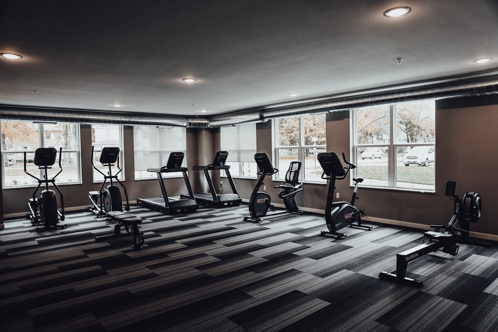 a gym with treadmills and weights on a checkered floor