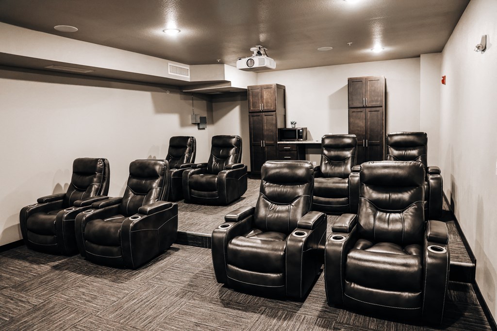 a room filled with leather chairs and a projector screen