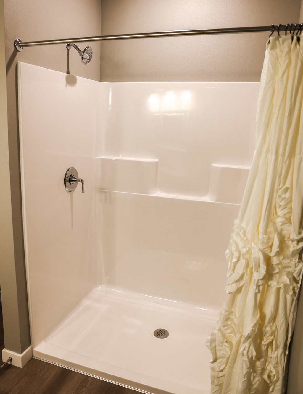 a white shower with a curtain in a bathroom