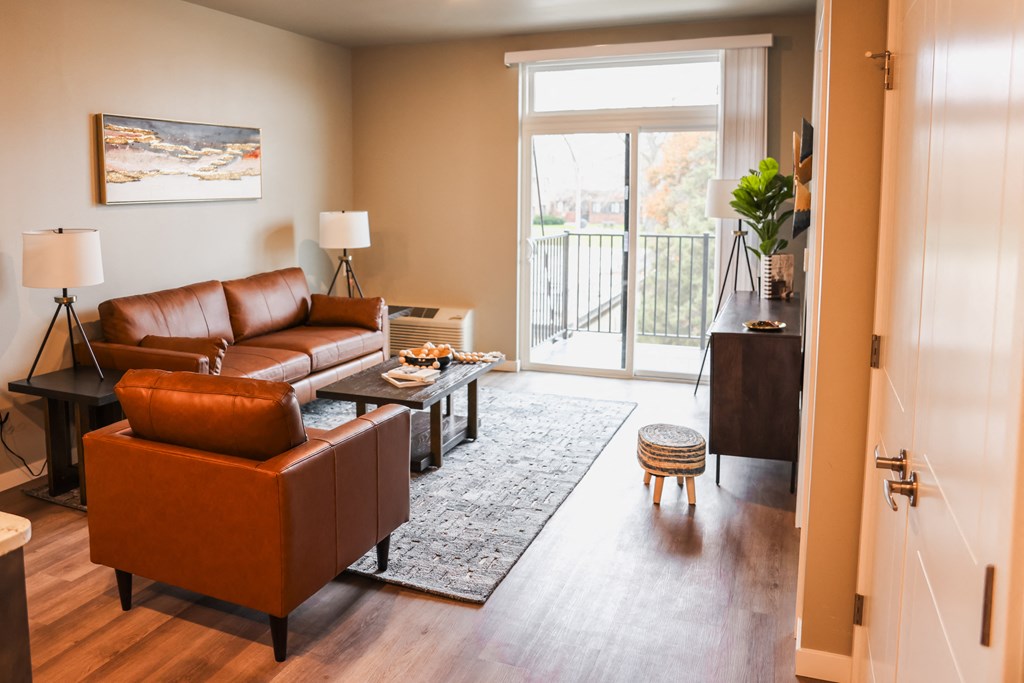 a living room with leather furniture and a sliding glass door