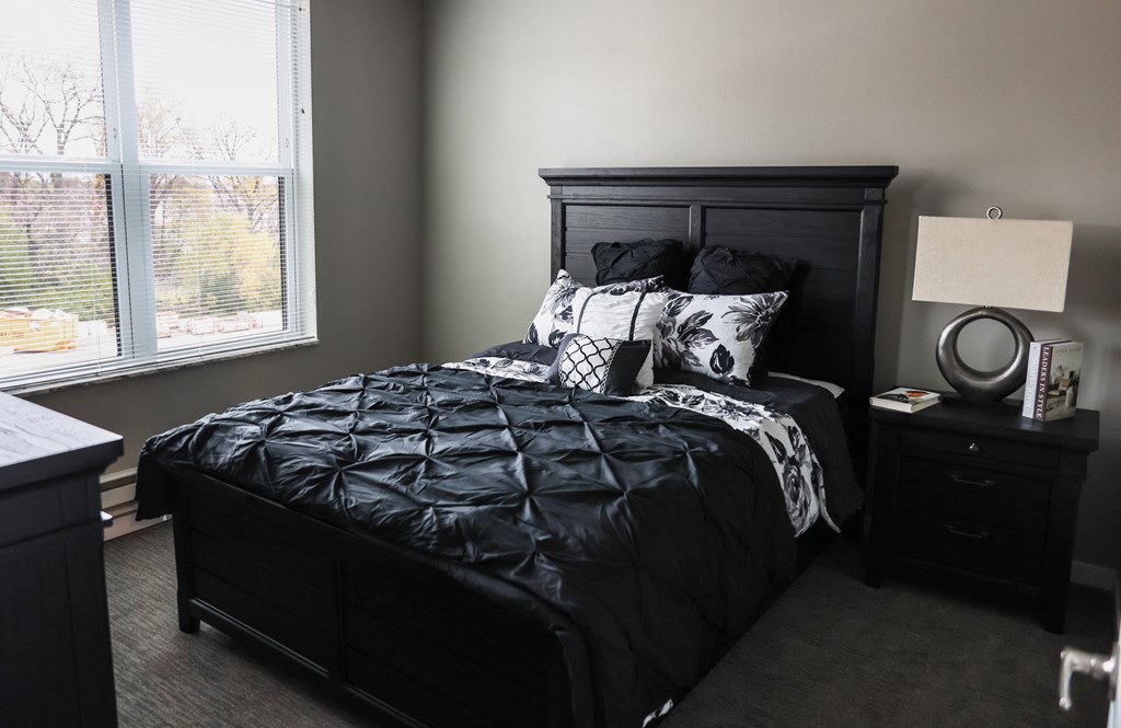 a bedroom with a bed and two night stands and a window