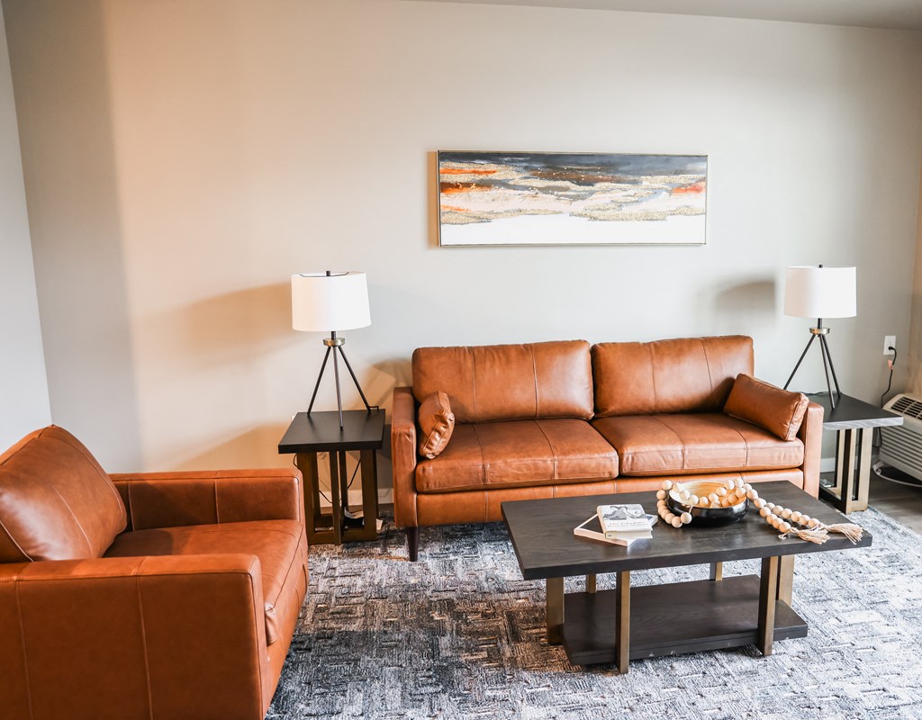 a living room with leather couches and a coffee table
