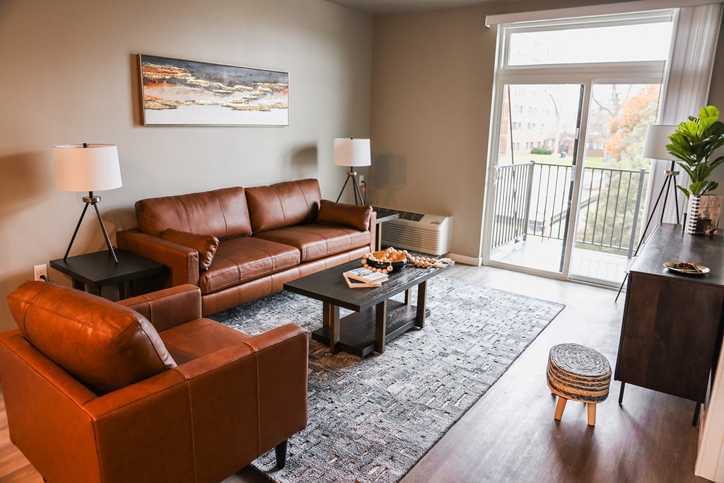 a living room with leather furniture and a sliding glass door
