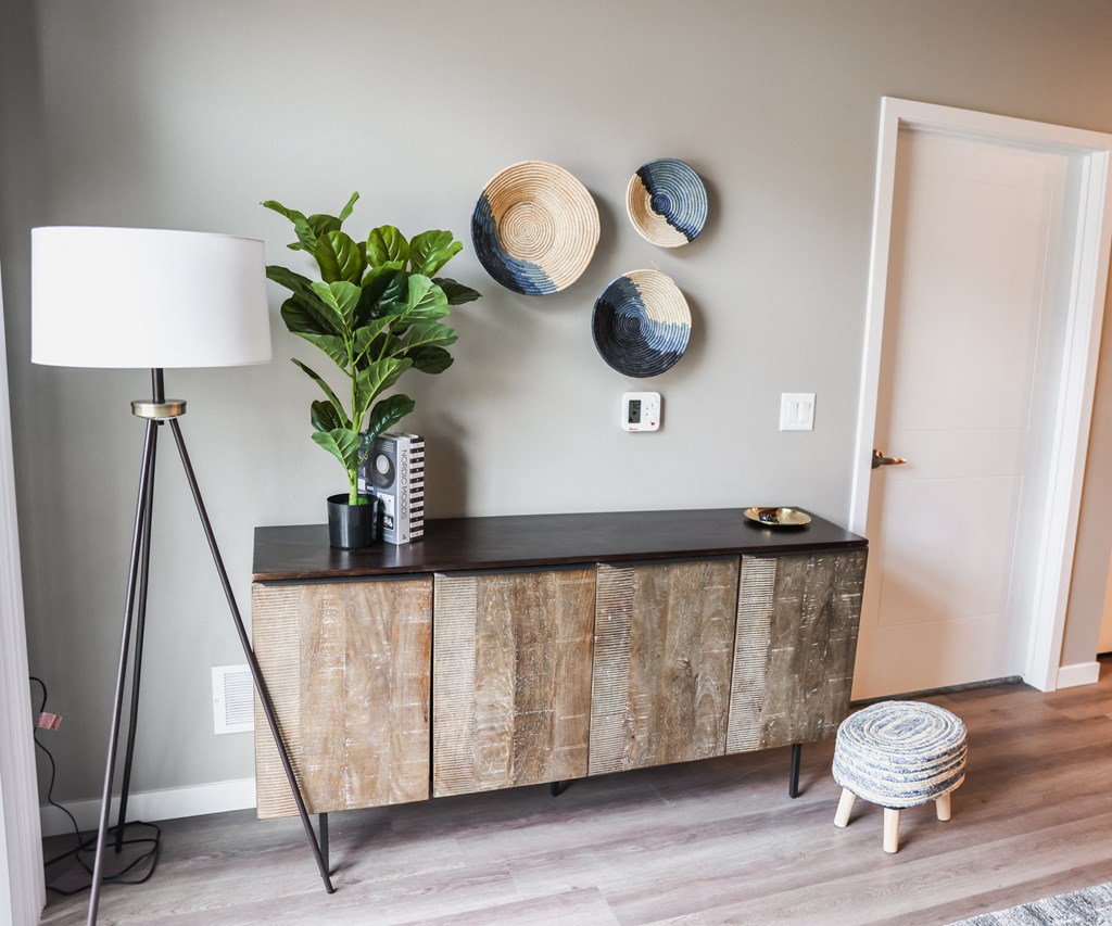 a living room with a dresser and two plates on the wall