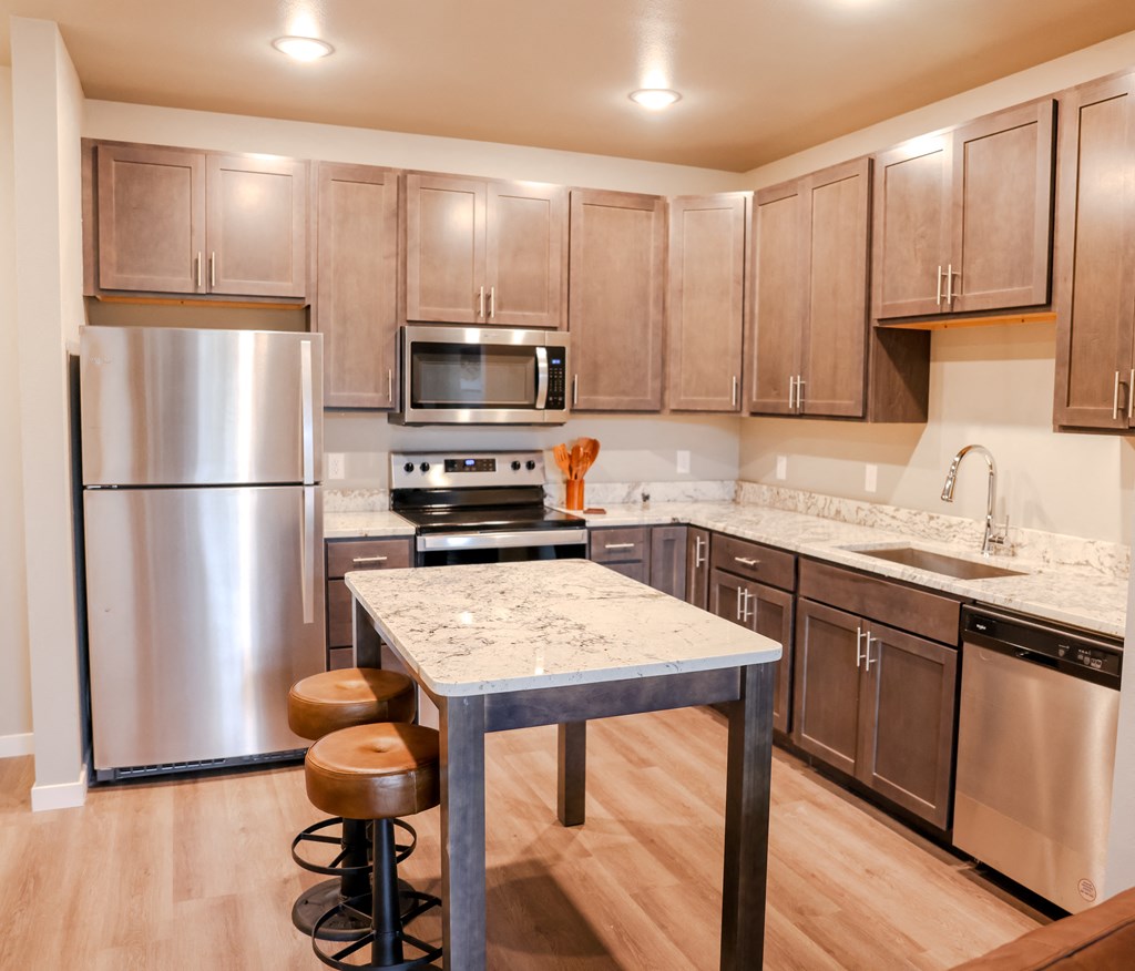 a kitchen with stainless steel appliances and a marble counter top